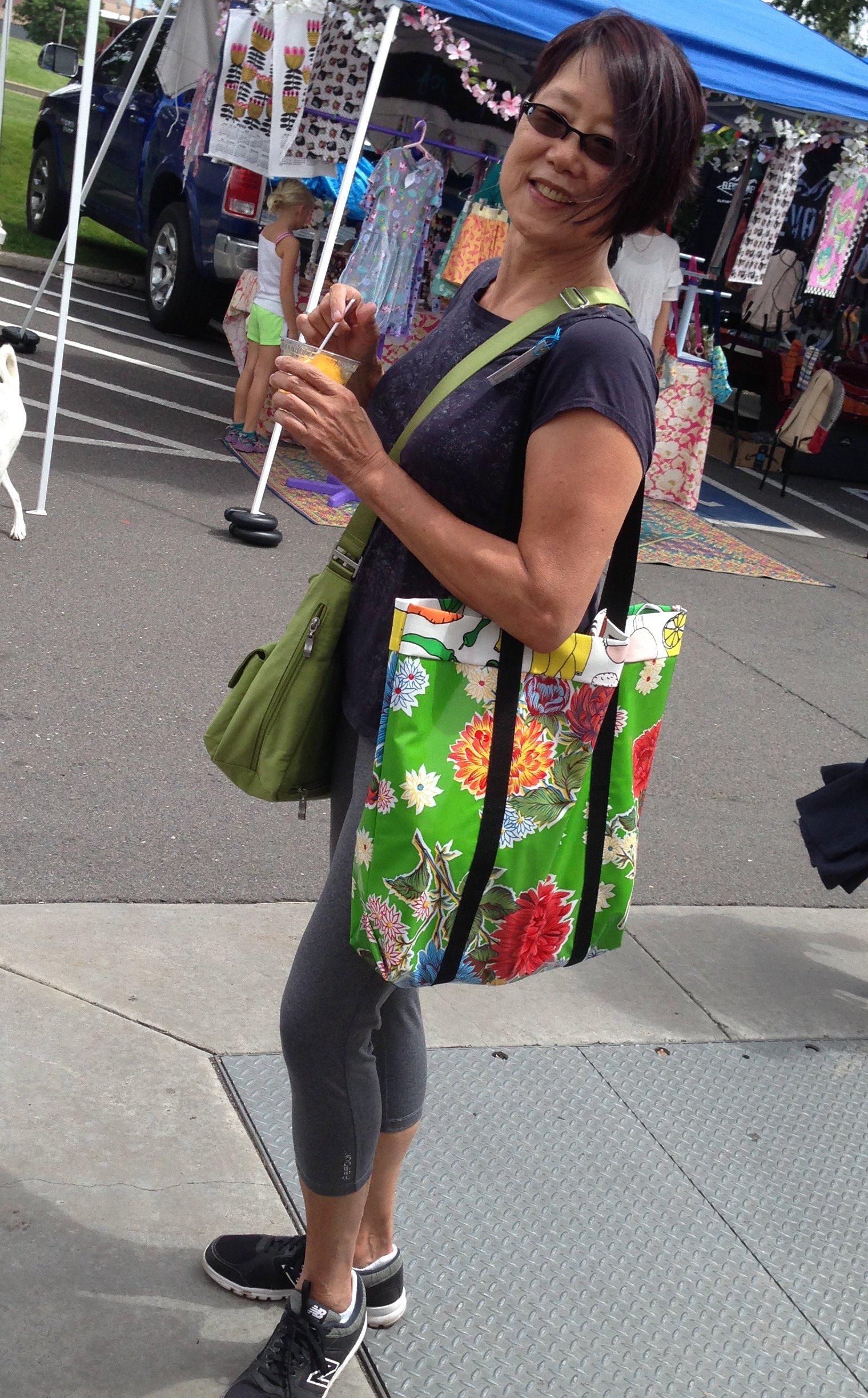 Woman with green Tallulah Art•Head oilcloth market bag over her shoulder