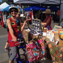 Woman on bicycle with her fuschia oilcloth Tallulah Art•Head market bag in bike basket