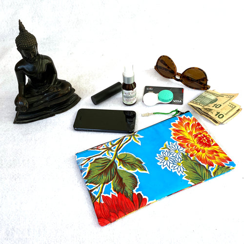 Small fuschia oilcloth zipper pouch with milagro zipper pull from Tallulah Art•Head with sunglasses, contact lens case, credit card, lipstick, cell phone and face toner spray.